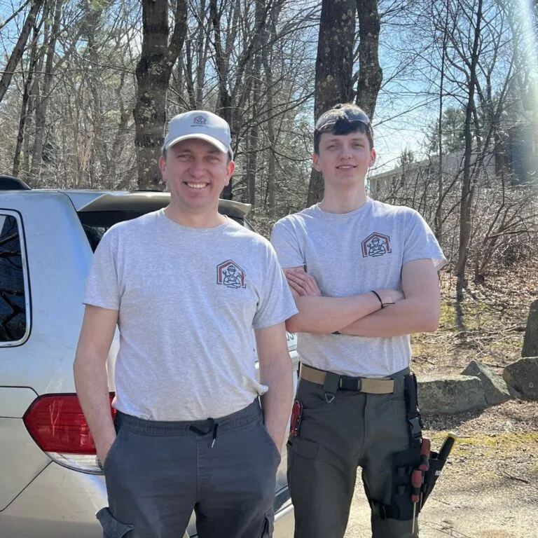Father-and-son team from Handymasters Painting Company, smiling in work attire, showcasing local expertise in residential painting services.